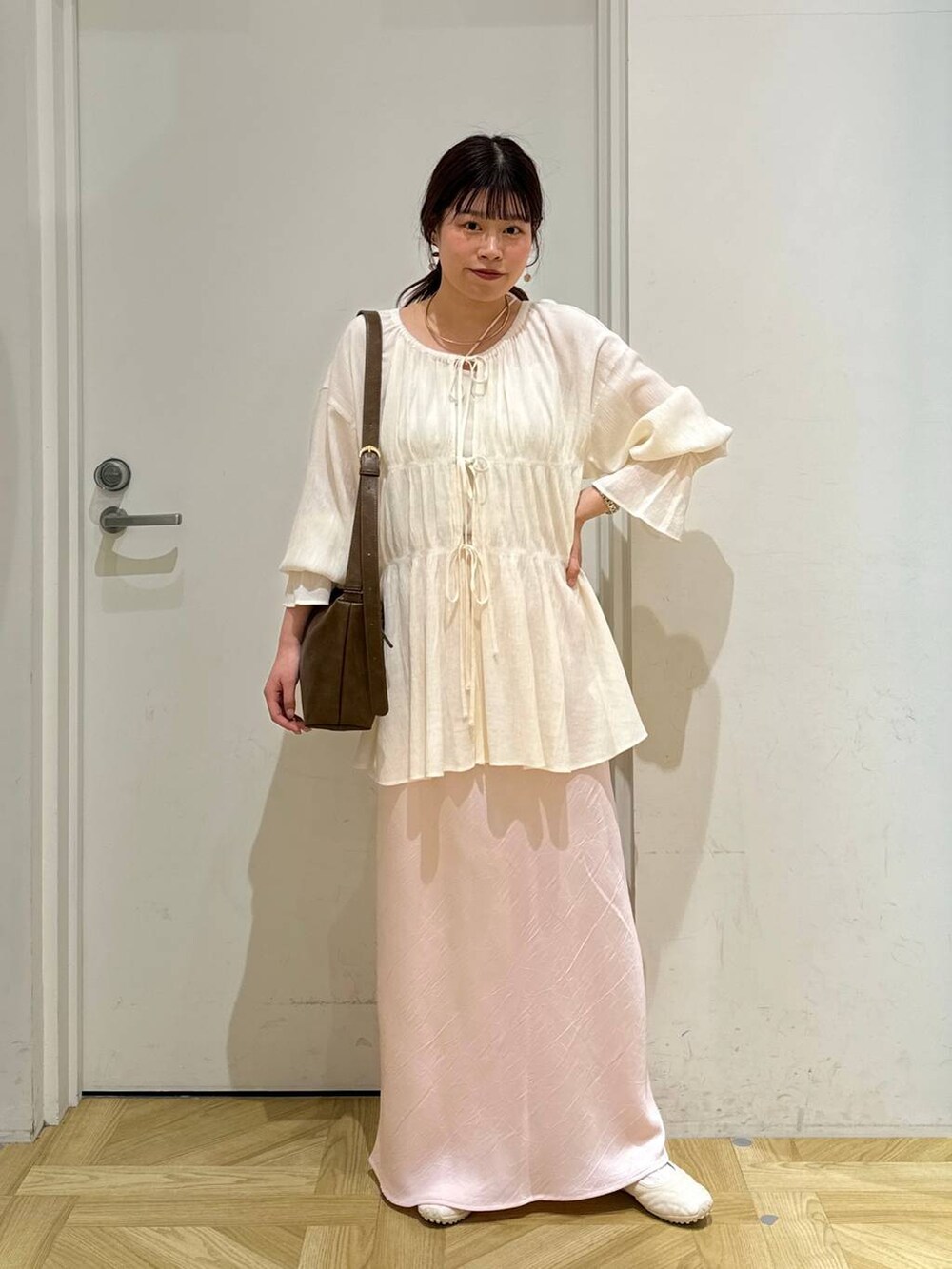 ホワイト系のスニーカー、ホワイト系のシャツ/ブラウス、ホワイト系のキャミソールを着用したレディースの春コーディネートの2枚目の写真