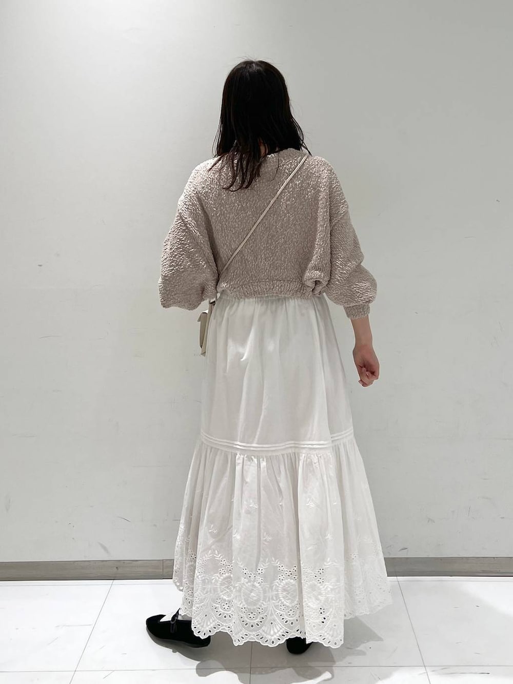 ホワイト系のスカート、ホワイト系のショルダーバッグ、その他のパンプスを着用したレディースの冬コーディネートの5枚目の写真