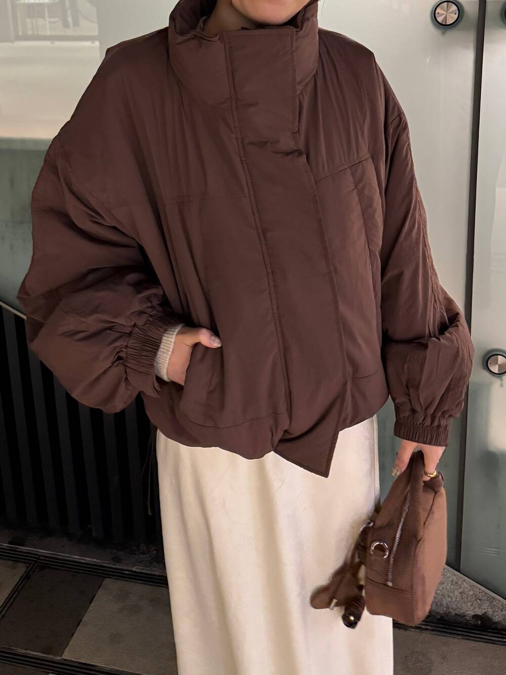 ブラウン系のその他アウター、ホワイト系のスカート、ブラウン系のボストンバッグを着用したレディースの秋コーディネートの5枚目の写真