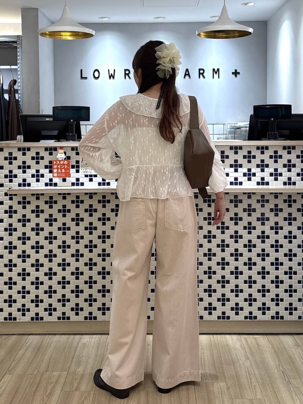 ピンク系のデニムパンツ、ブラウン系のローファー、ブラウン系のショルダーバッグを着用したレディースの春コーディネートの4枚目の写真