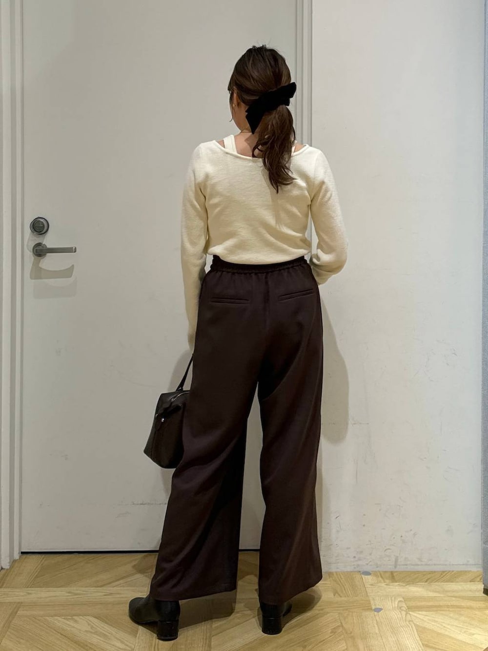 ブラック系のブーツ、ブラウン系のショルダーバッグ、ホワイト系のブルゾンを着用したレディースの冬コーディネートの8枚目の写真