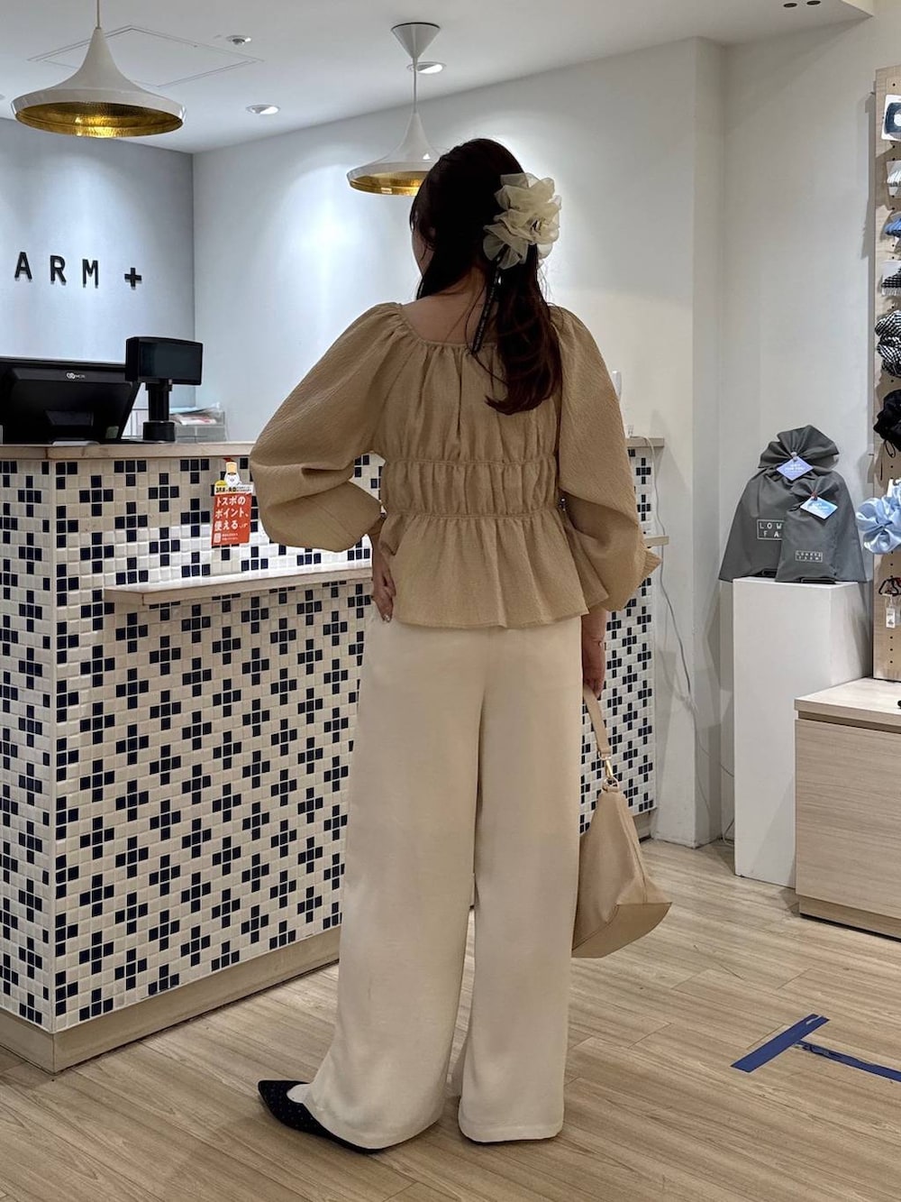 ブラック系のパンプス、ベージュ系のショルダーバッグ、ホワイト系のその他パンツを着用したレディースの春コーディネートの4枚目の写真