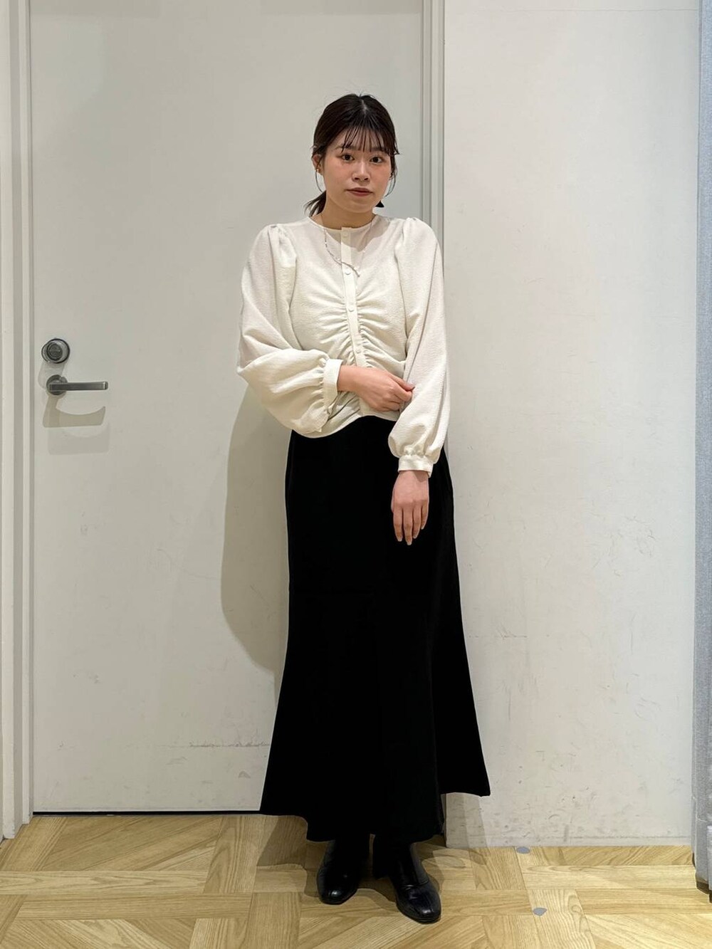 ブラック系のブーツ、ホワイト系のシャツ/ブラウス、ブラウン系のトレンチコートを着用したレディースの春コーディネートの6枚目の写真