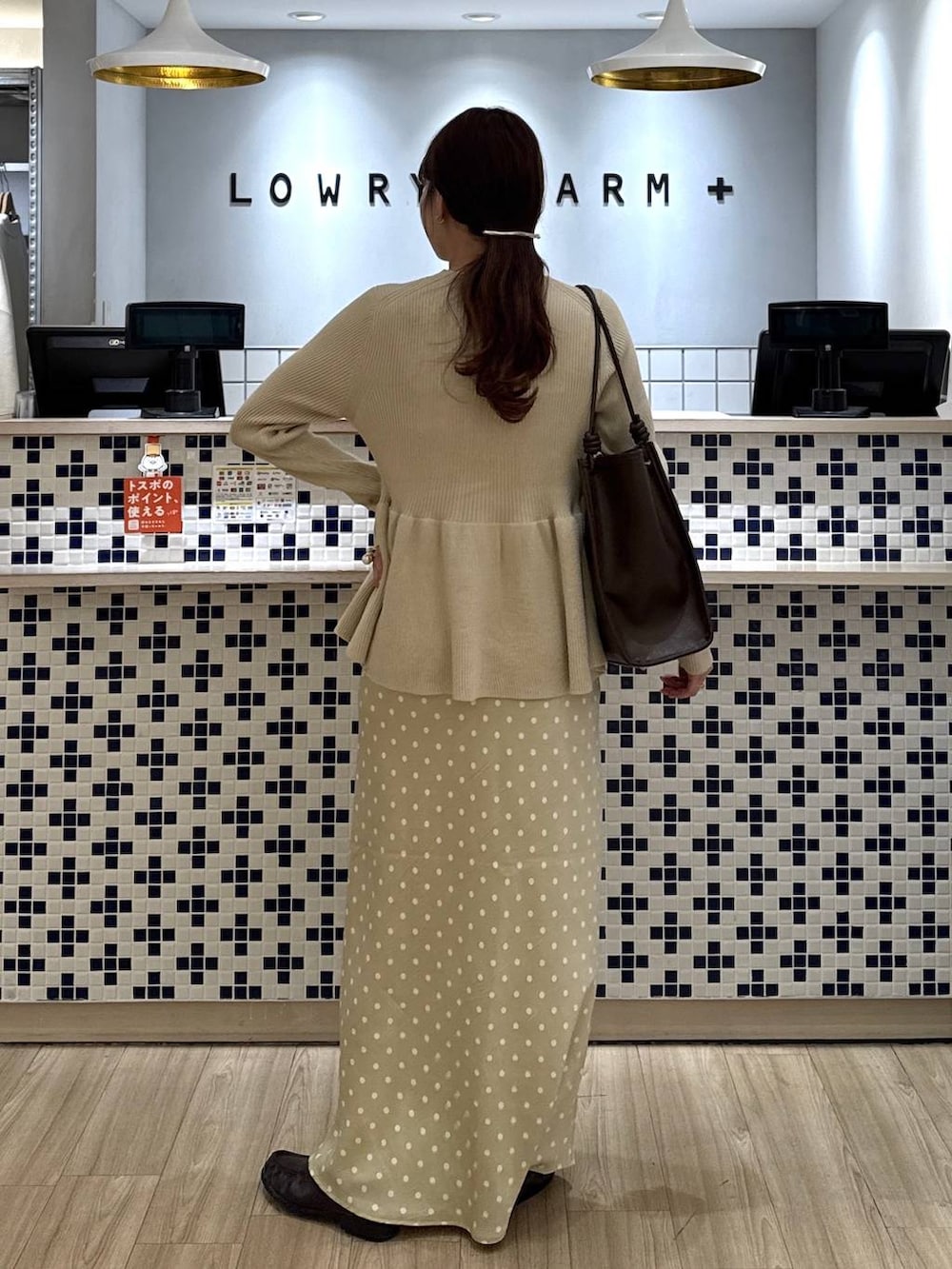 ホワイト系のスカート、ブラウン系のローファー、ブラウン系のトートバッグを着用したレディースの春コーディネートの4枚目の写真