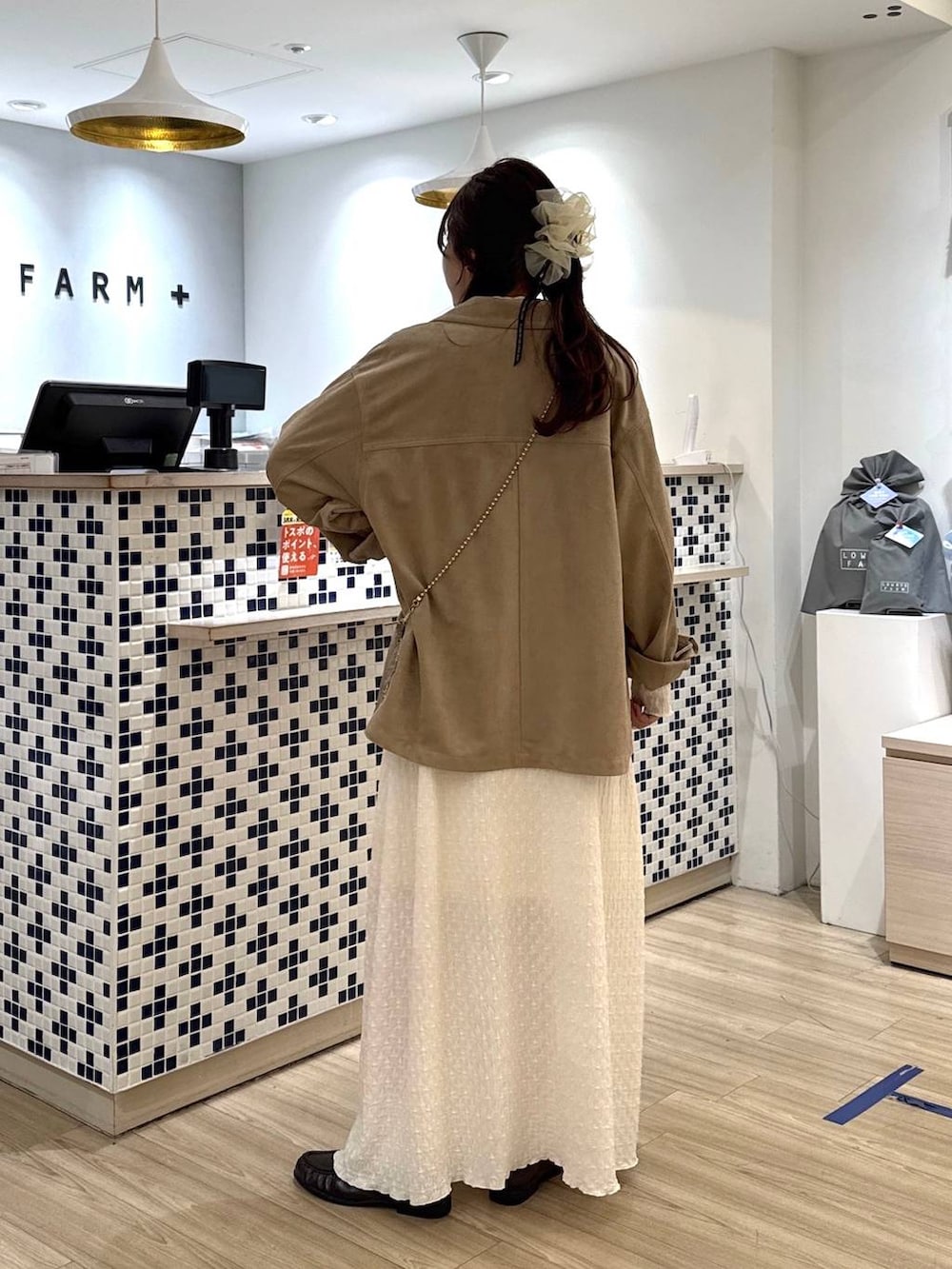 ゴールド系のショルダーバッグ、ベージュ系のテーラードジャケット、ブラウン系のローファーを着用したレディースの春コーディネートの4枚目の写真