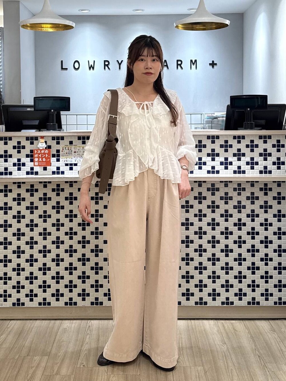 ピンク系のデニムパンツ、ブラウン系のローファー、ブラウン系のショルダーバッグを着用したレディースの春コーディネートの2枚目の写真