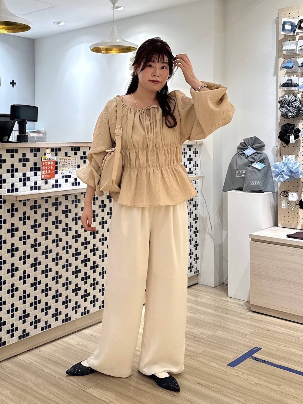 ブラック系のパンプス、ベージュ系のショルダーバッグ、ホワイト系のその他パンツを着用したレディースの春コーディネートの2枚目の写真