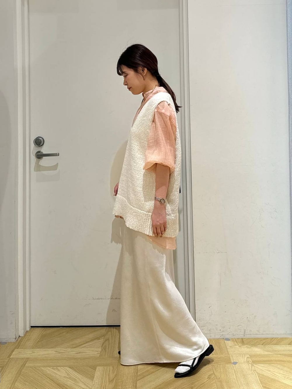 ブラック系のサンダル、ホワイト系のニット/セーター、ブラック系のショルダーバッグを着用したレディースの春コーディネートの4枚目の写真