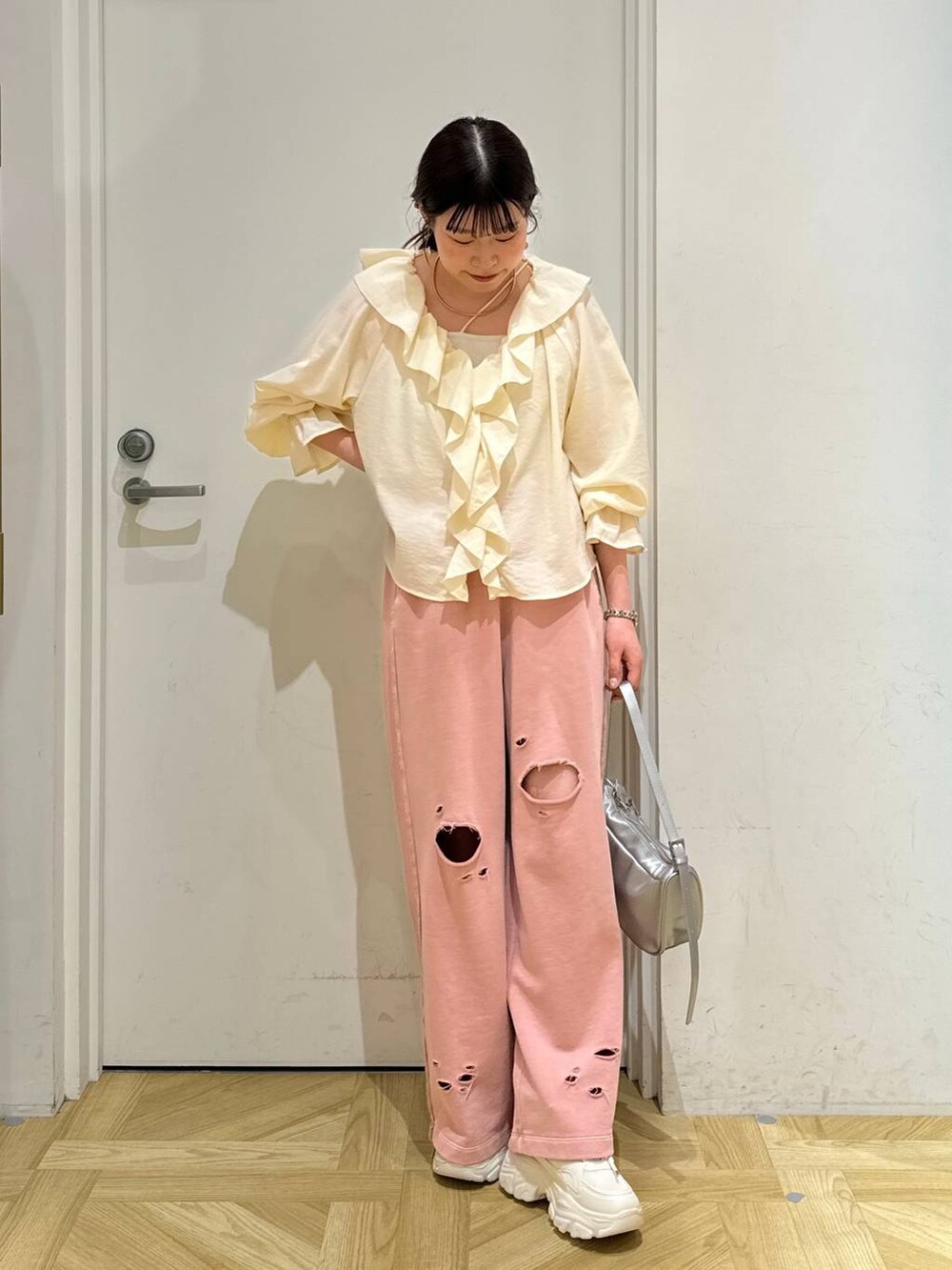 ホワイト系のシャツ/ブラウス、ホワイト系のスニーカー、シルバー系のトートバッグを着用したレディースの春コーディネートの2枚目の写真