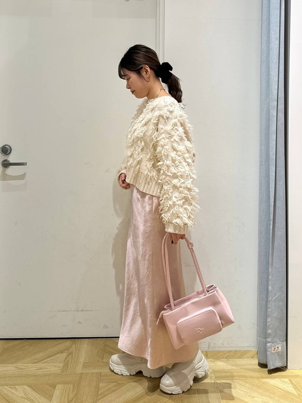 ホワイト系のブルゾン、ピンク系のショルダーバッグ、ホワイト系のブーツを着用したレディースの冬コーディネートの7枚目の写真