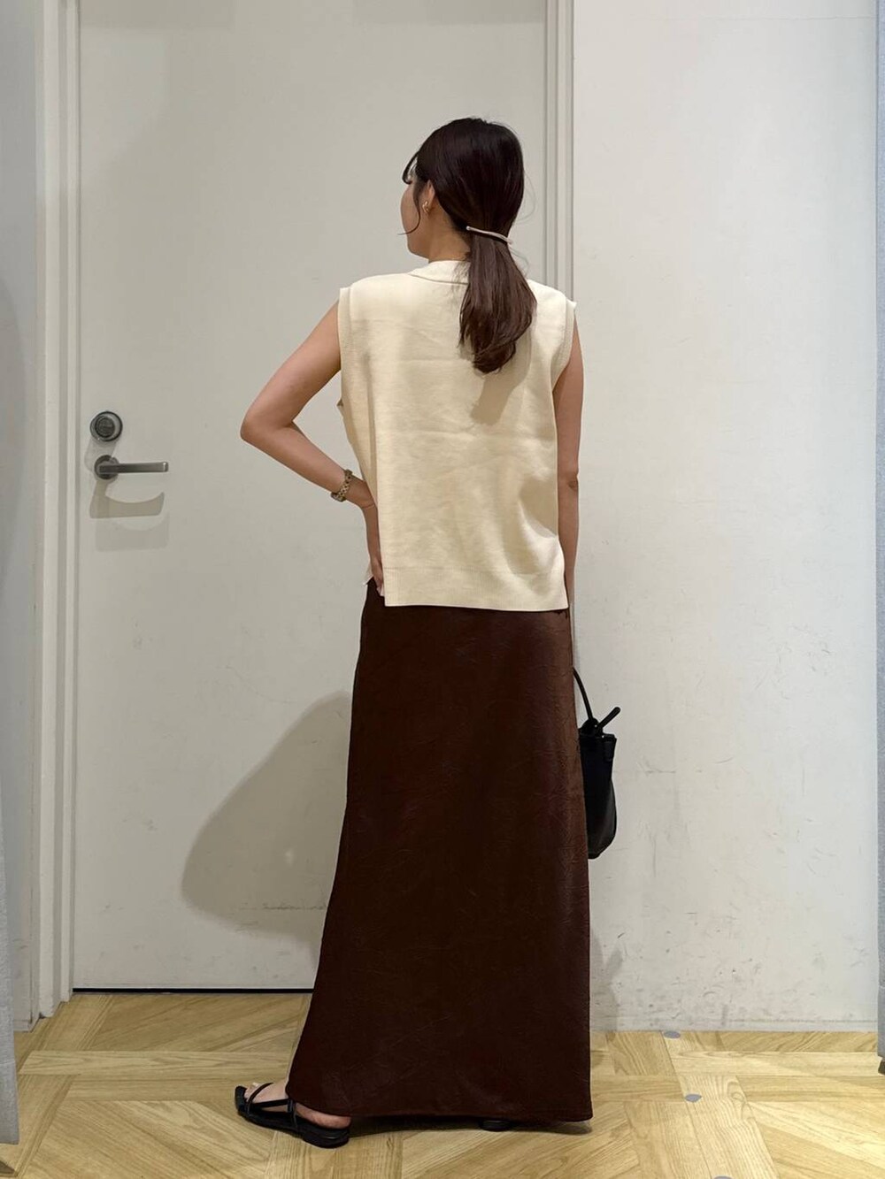 ブラック系のサンダル、ブラウン系のスカート、ブラック系のショルダーバッグを着用したレディースの夏コーディネートの5枚目の写真