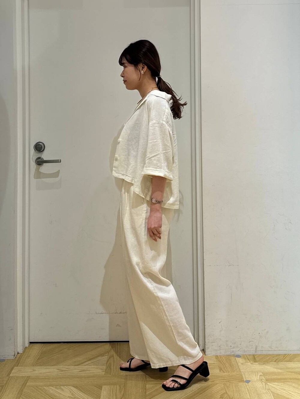 ホワイト系のシャツ/ブラウス、ブラック系のサンダル、ベージュ系のその他パンツを着用したレディースの春コーディネートの3枚目の写真