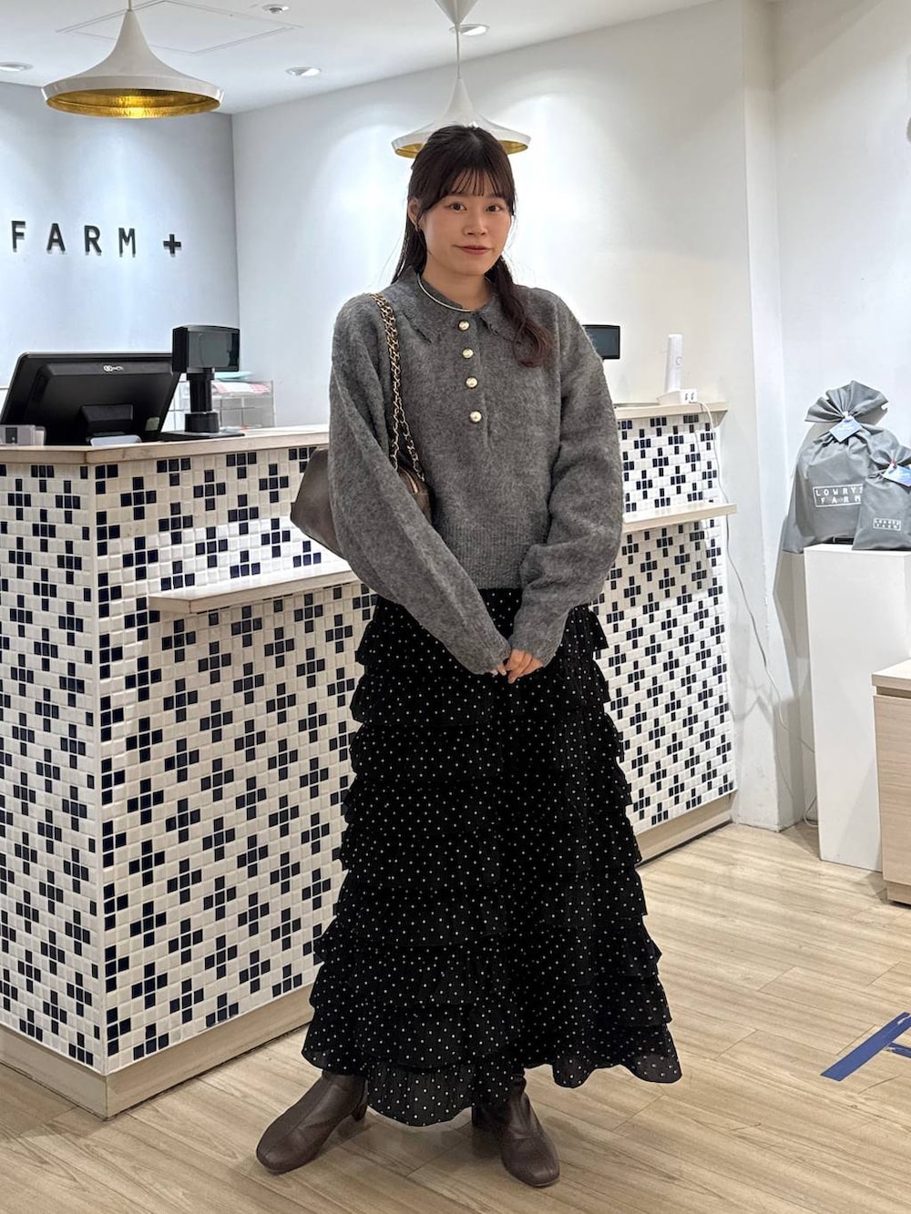 その他のスカート、ブラウン系のブーツ、グレー系のニット/セーターを着用したレディースの冬コーディネートの2枚目の写真