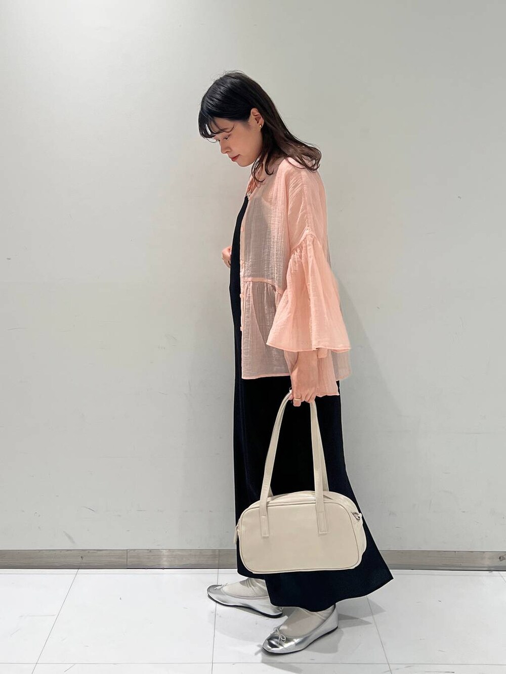 ホワイト系のハンドバッグ、グレー系のバレエシューズ、ブラック系のワンピースを着用したレディースの春コーディネートの4枚目の写真