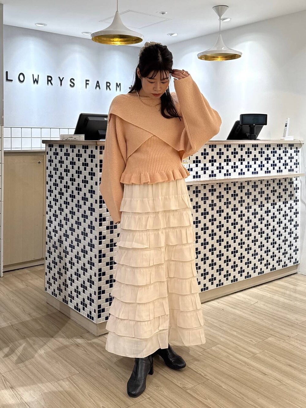 ホワイト系のスカート、ピンク系のニット/セーター、ブラック系のブーツを着用したレディースの秋コーディネートの2枚目の写真