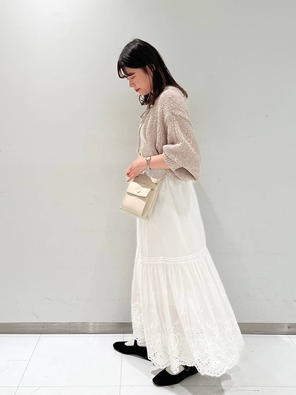 ホワイト系のスカート、ホワイト系のショルダーバッグ、その他のパンプスを着用したレディースの冬コーディネートの4枚目の写真