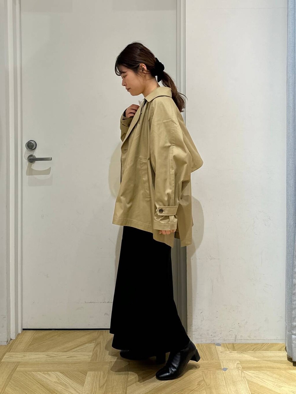 ブラック系のブーツ、ホワイト系のシャツ/ブラウス、ブラウン系のトレンチコートを着用したレディースの春コーディネートの4枚目の写真