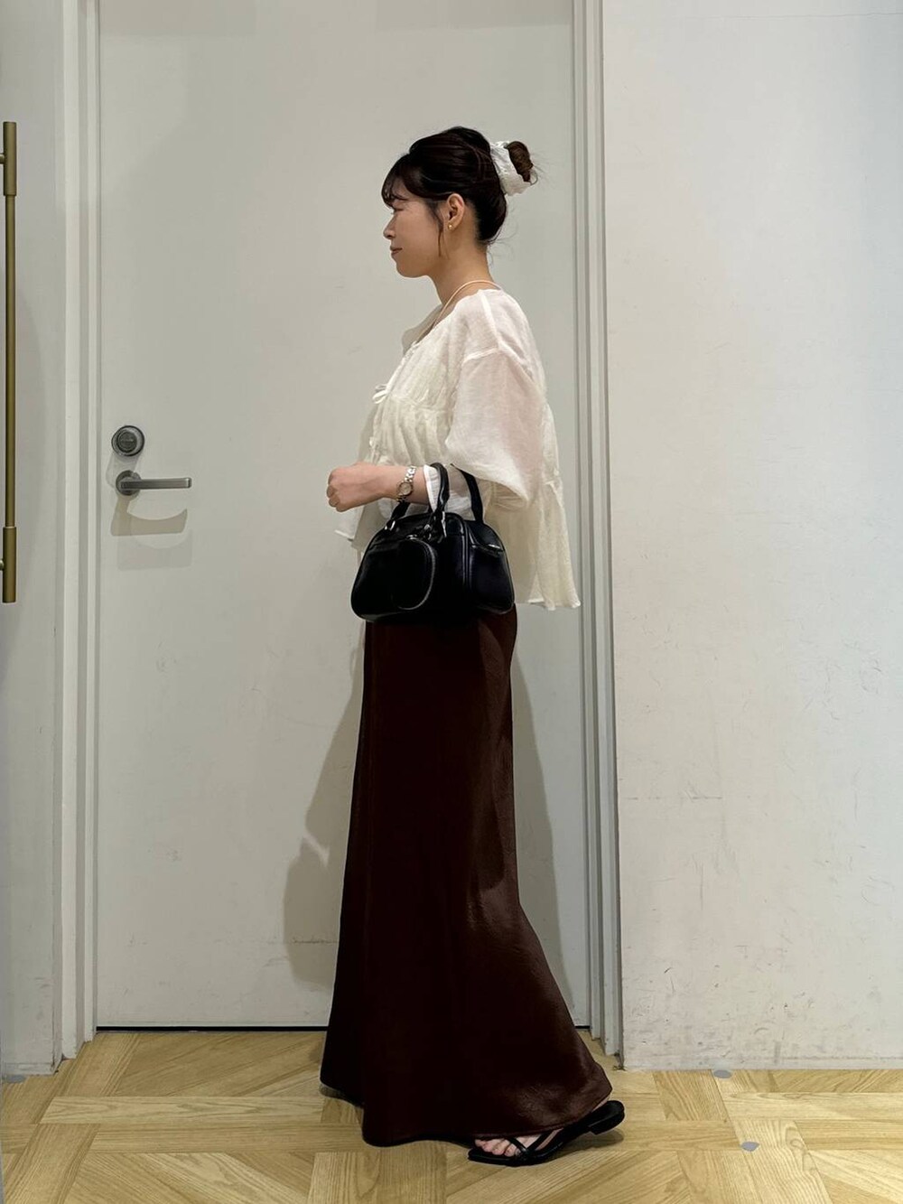 ブラック系のサンダル、ホワイト系のシャツ/ブラウス、ブラウン系のスカートを着用したレディースの夏コーディネートの3枚目の写真