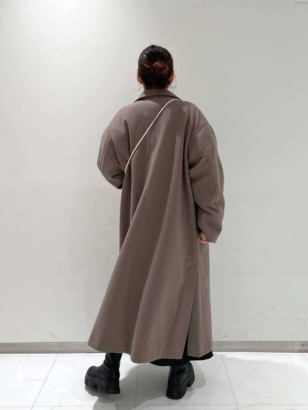 ホワイト系のショルダーバッグ、ブラウン系のチェスターコート、ブラック系のブーツを着用したレディースの冬コーディネートの3枚目の写真