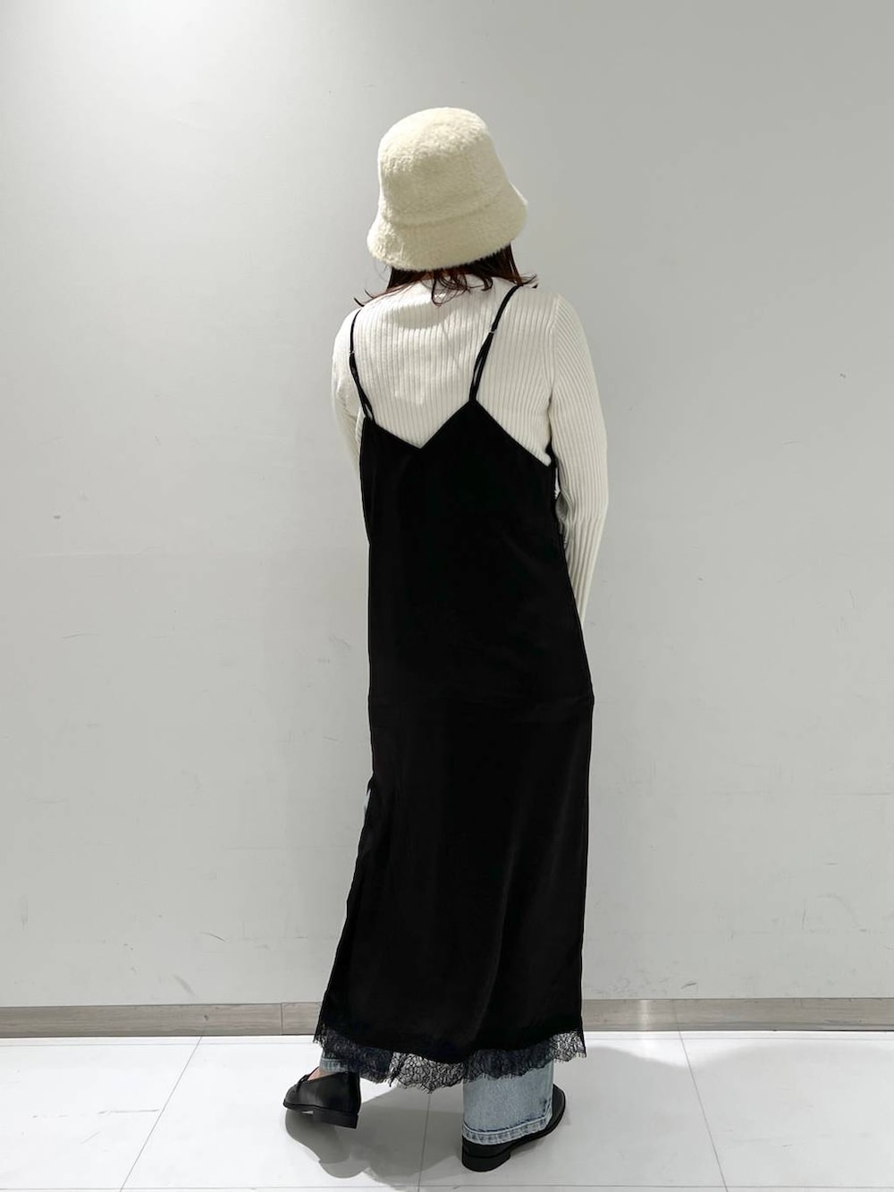 ブルー系のデニムパンツ、ブラック系のローファー、ホワイト系のニット/セーターを着用したレディースの秋コーディネートの4枚目の写真
