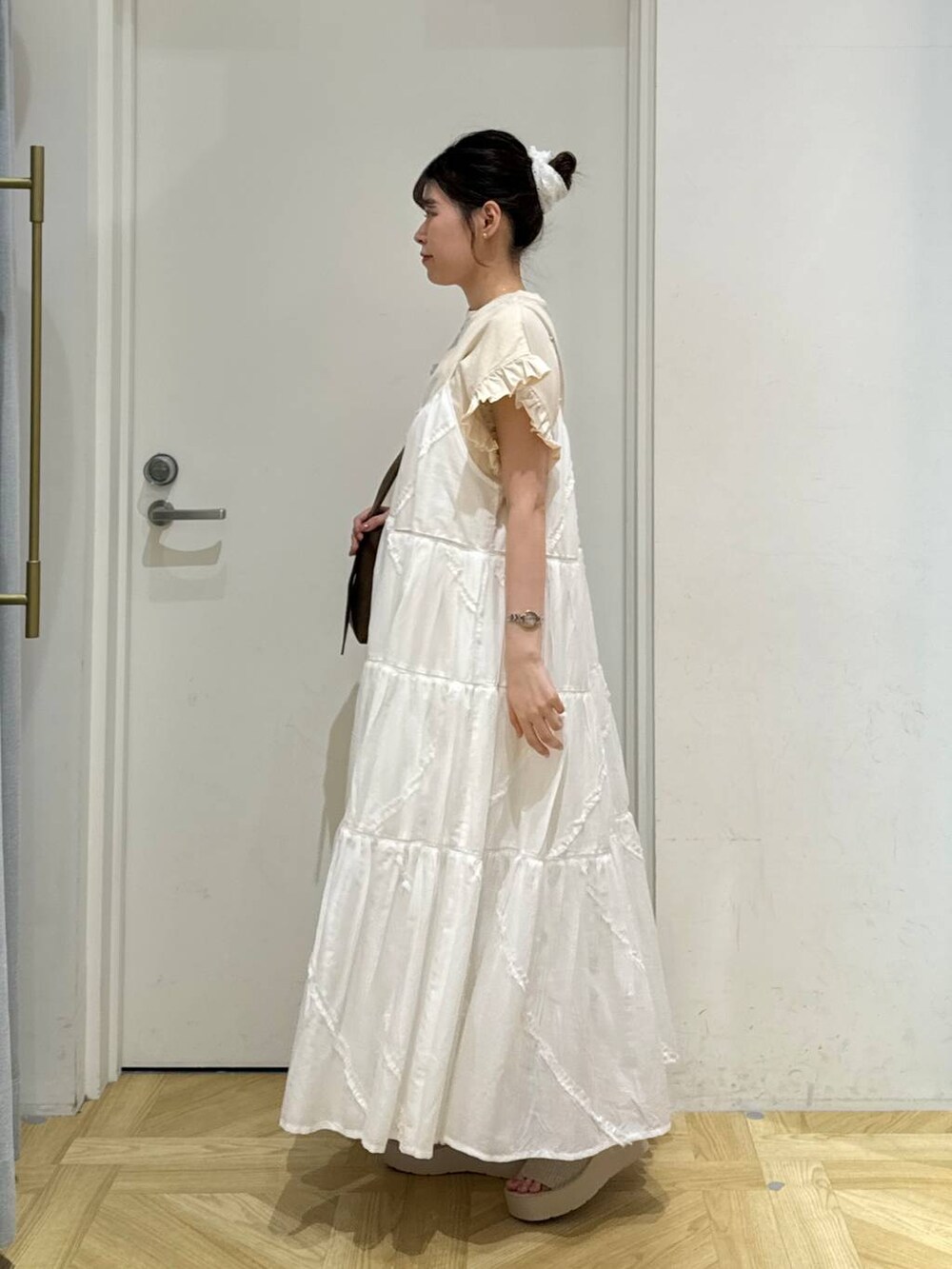 ホワイト系のサンダル、ホワイト系のワンピース、ブラウン系のショルダーバッグを着用したレディースの夏コーディネートの3枚目の写真