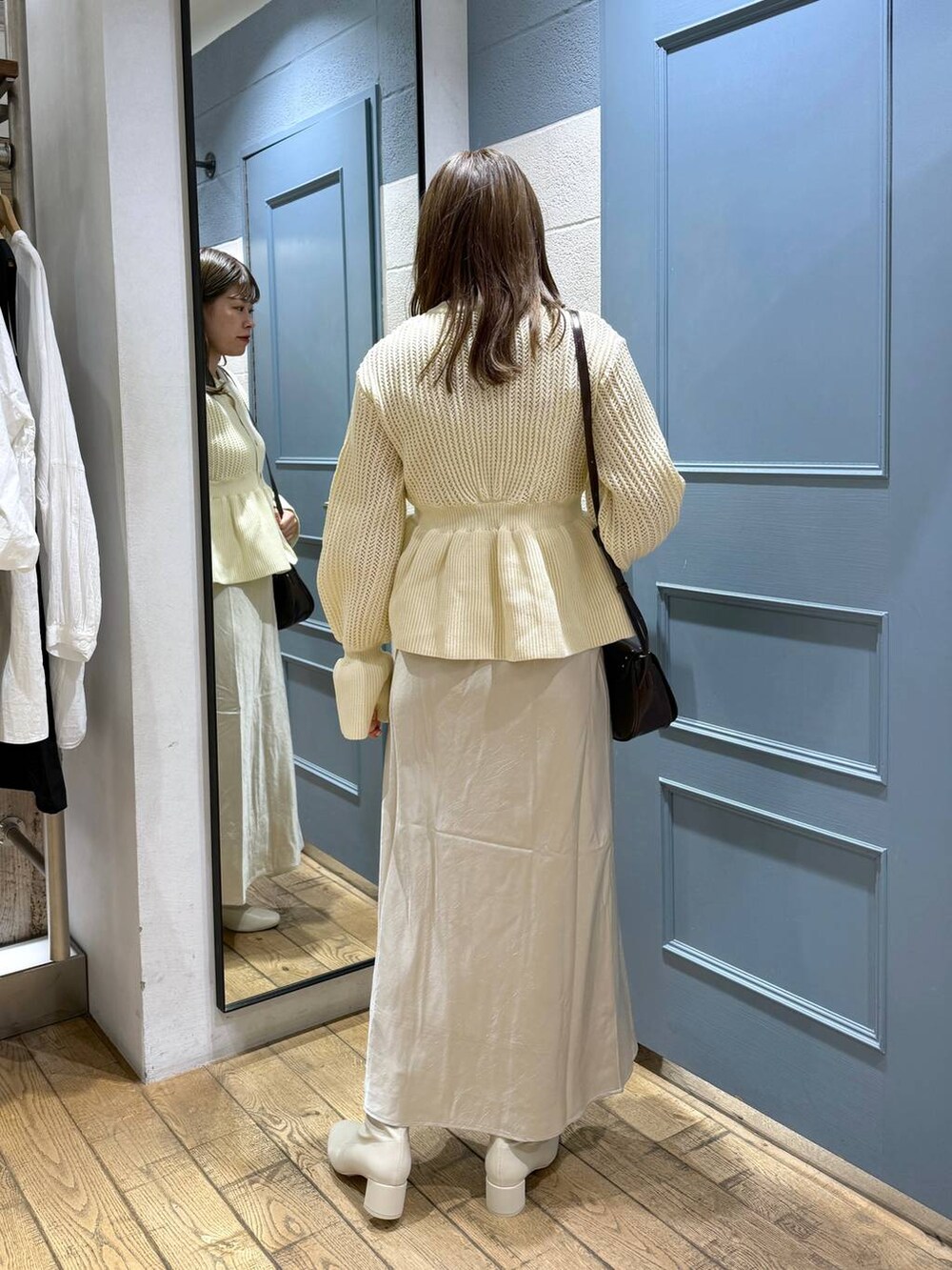 ブラウン系のショルダーバッグ、ホワイト系のブーツ、ホワイト系のカーディガン/ボレロを着用したレディースの秋コーディネートの4枚目の写真