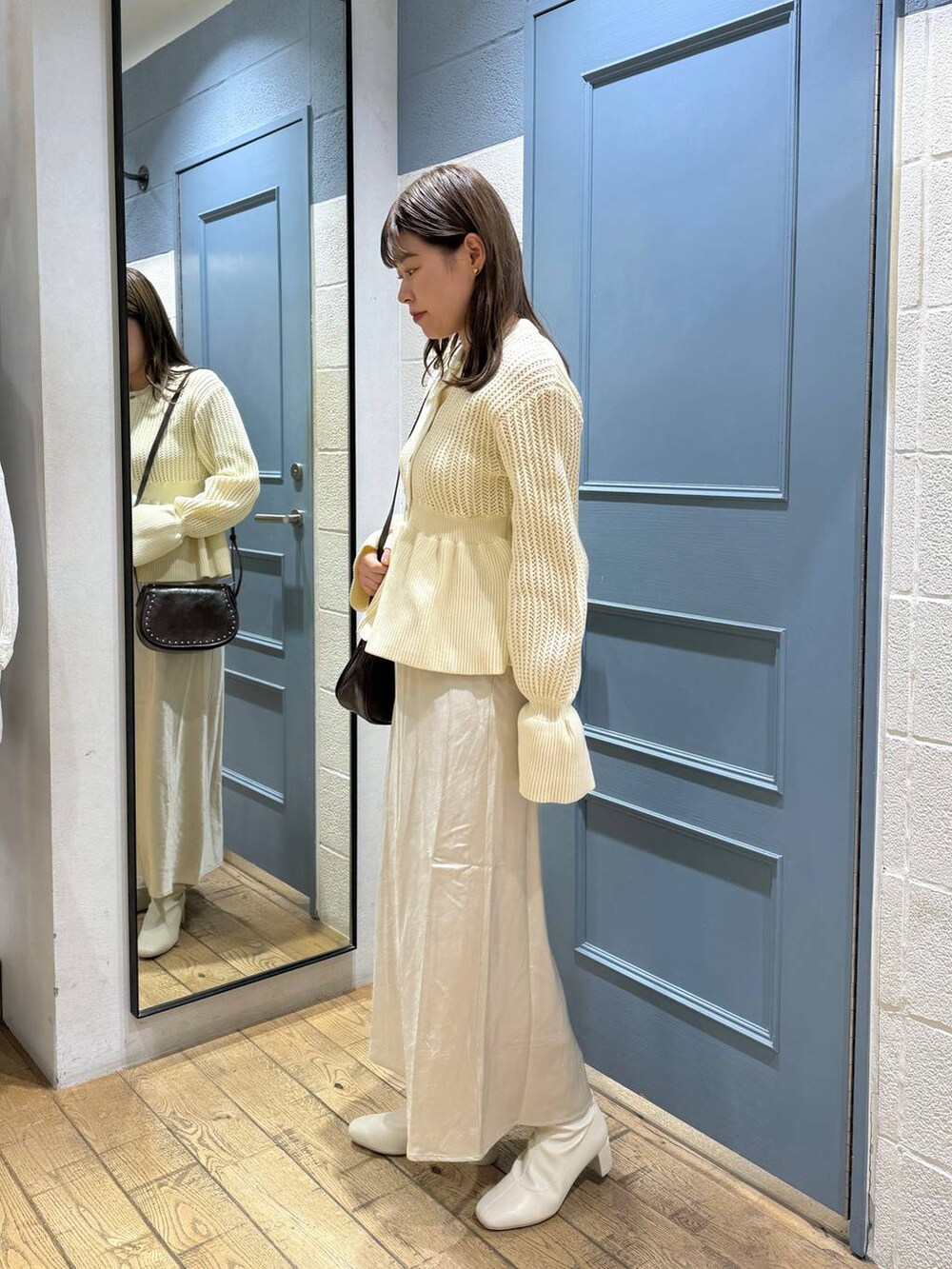 ブラウン系のショルダーバッグ、ホワイト系のブーツ、ホワイト系のカーディガン/ボレロを着用したレディースの秋コーディネートの3枚目の写真