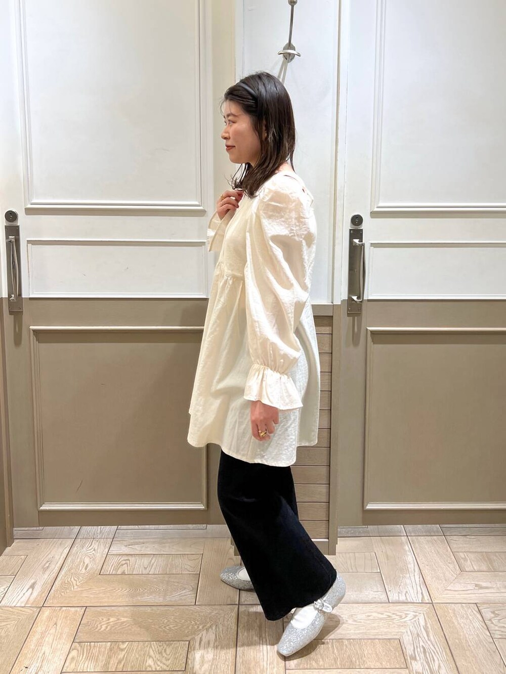 シルバー系のパンプス、ブラック系のデニムパンツ、ホワイト系のTシャツ/カットソーを着用したレディースの冬コーディネートの2枚目の写真