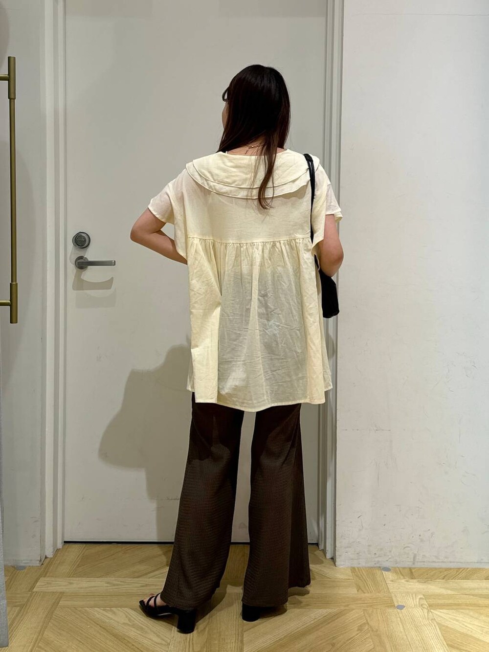 ブラック系のサンダル、ブラック系のショルダーバッグ、ブラウン系のその他パンツを着用したレディースの春コーディネートの4枚目の写真