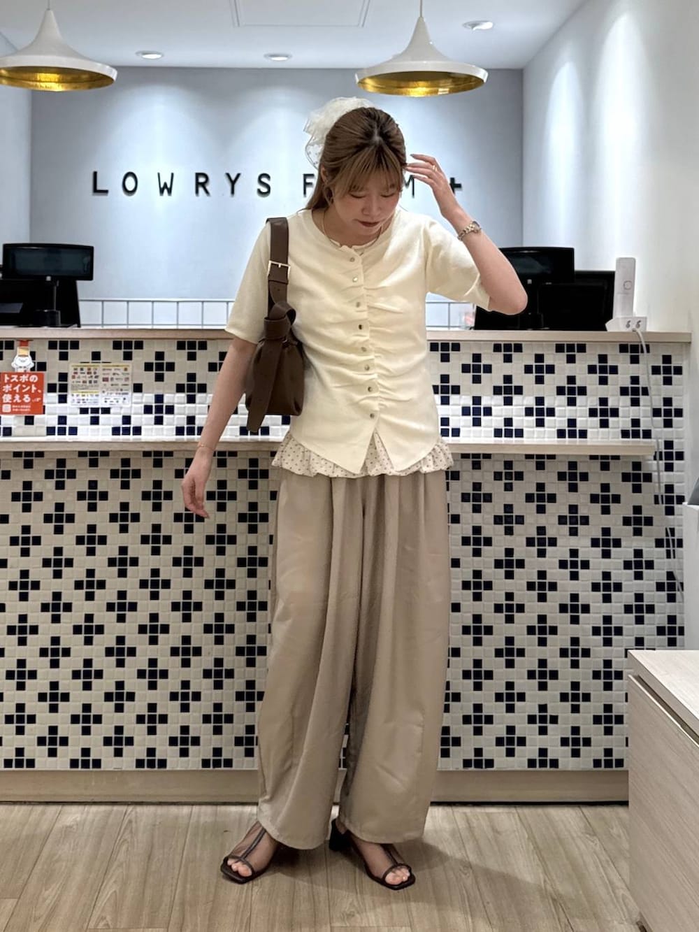 ベージュ系のその他パンツ、ブラウン系のショルダーバッグ、ブラウン系のサンダルを着用したレディースの夏コーディネートの3枚目の写真