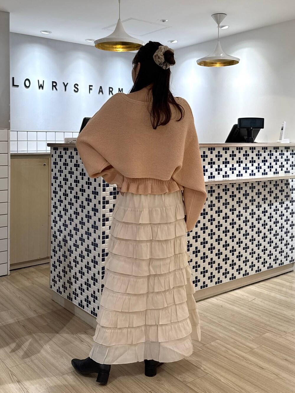 ホワイト系のスカート、ピンク系のニット/セーター、ブラック系のブーツを着用したレディースの秋コーディネートの5枚目の写真