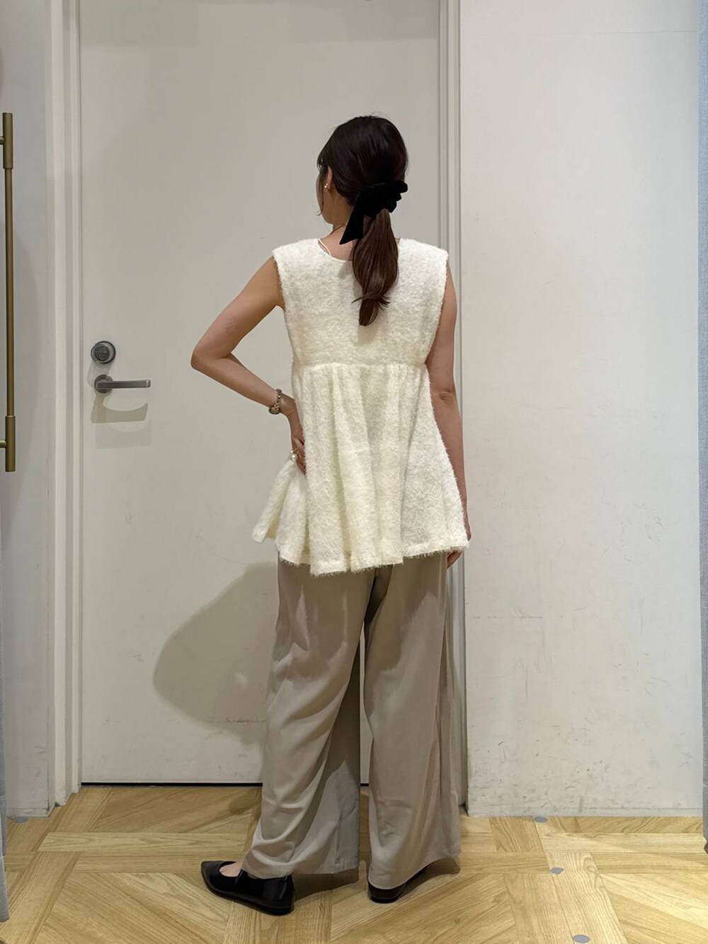 ベージュ系のその他パンツ、ブラック系のパンプス、ホワイト系のベストを着用したレディースの秋コーディネートの6枚目の写真