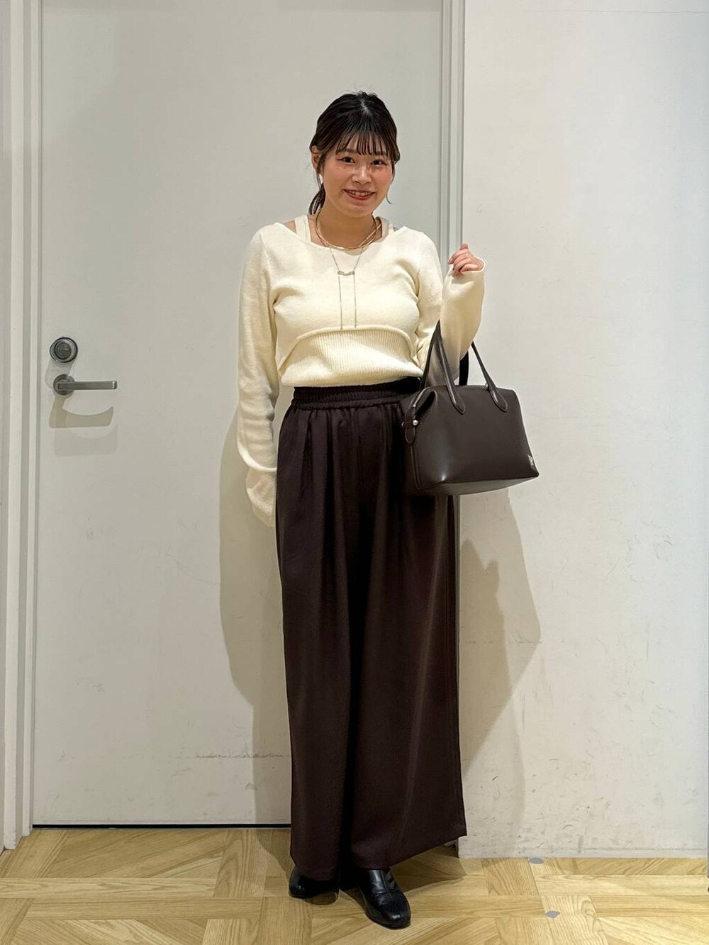 ブラック系のブーツ、ブラウン系のショルダーバッグ、ホワイト系のブルゾンを着用したレディースの冬コーディネートの5枚目の写真