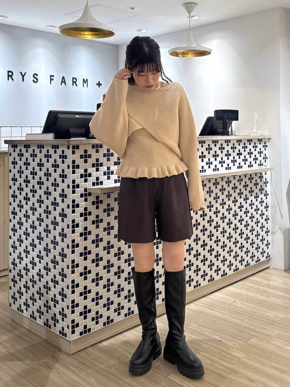 ブラウン系のステンカラーコート、ブラウン系のその他パンツ、ブラック系のブーツを着用したレディースの秋コーディネートの6枚目の写真