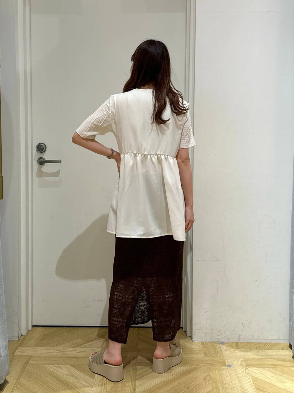 ホワイト系のサンダル、ブラウン系のスカート、ホワイト系のTシャツ/カットソーを着用したレディースの春コーディネートの4枚目の写真