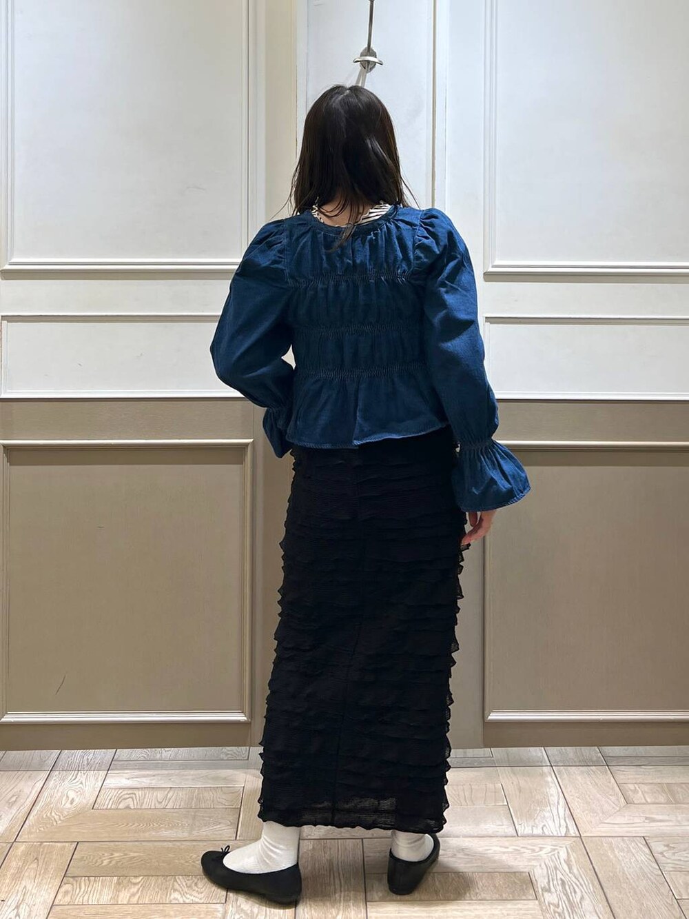 ブラック系のスカート、ブラック系のバレエシューズ、ホワイト系のTシャツ/カットソーを着用したレディースの春コーディネートの3枚目の写真
