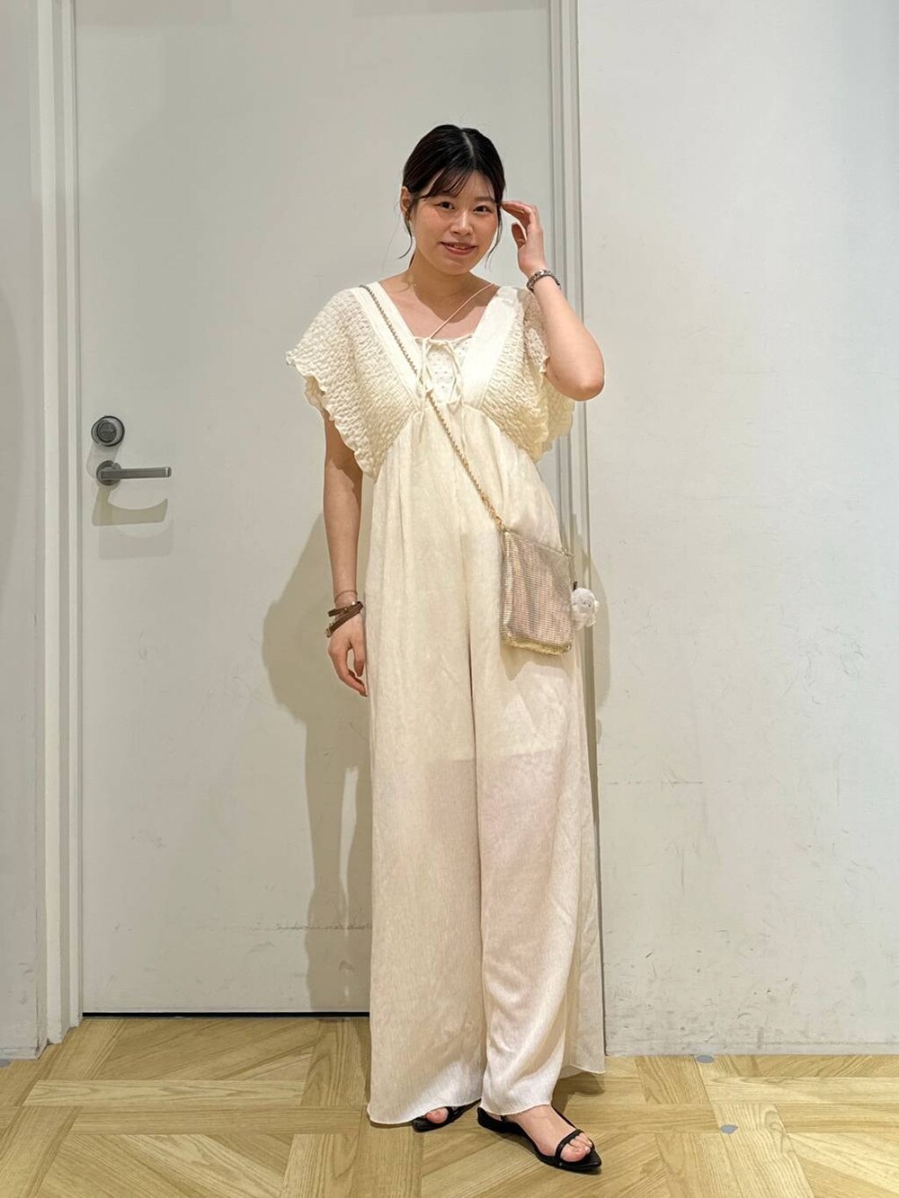 ゴールド系のショルダーバッグ、ブラック系のサンダル、ホワイト系のサロペット/オーバーオールを着用したレディースの夏コーディネートの5枚目の写真