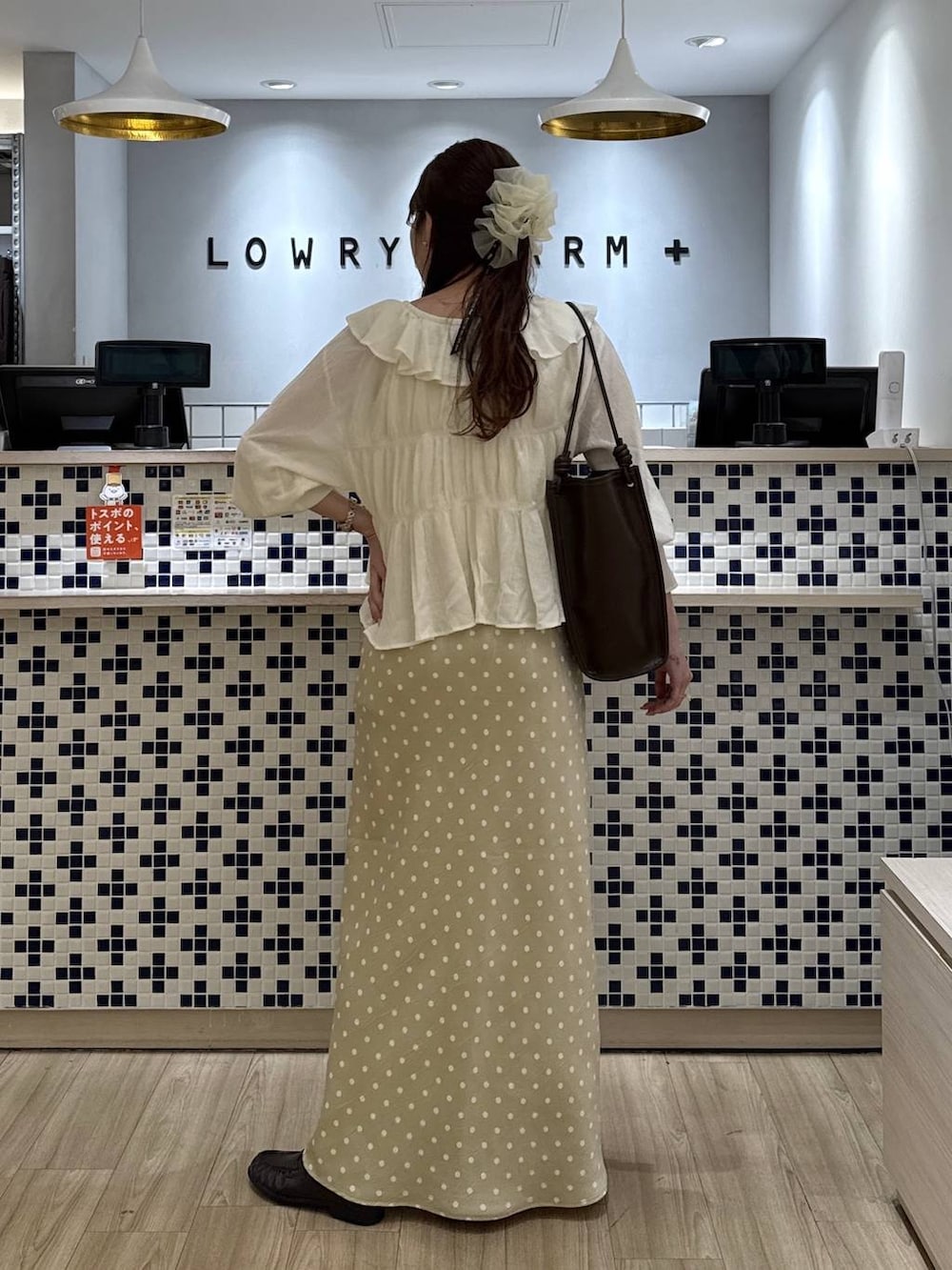 ホワイト系のスカート、ブラウン系のローファー、ホワイト系のタンクトップを着用したレディースの春コーディネートの5枚目の写真