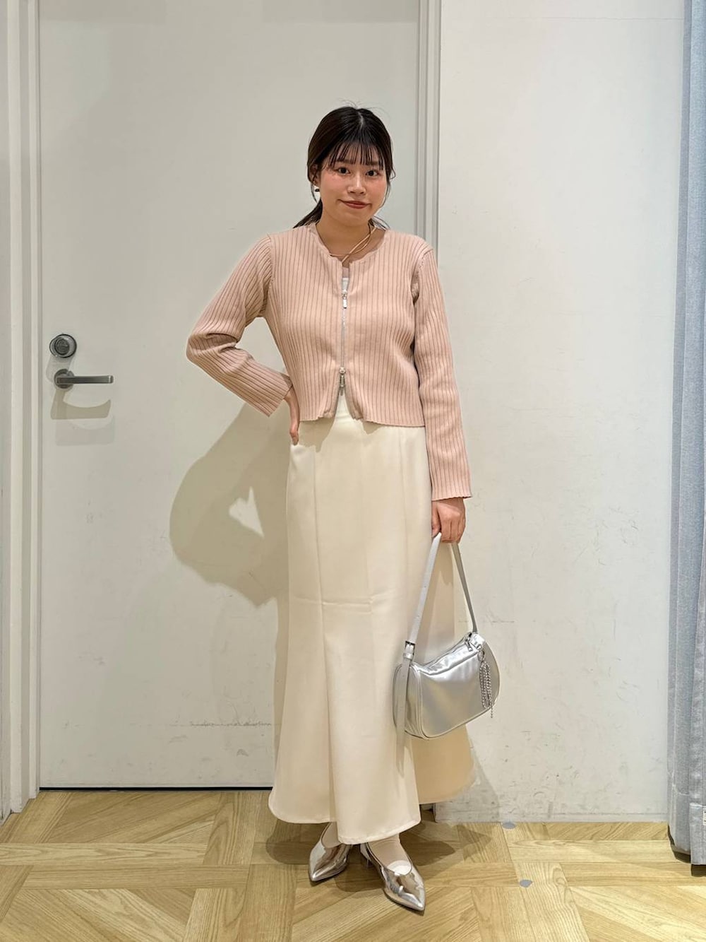 ピンク系のカーディガン/ボレロ、シルバー系のトートバッグ、シルバー系のパンプスを着用したレディースの春コーディネートの2枚目の写真