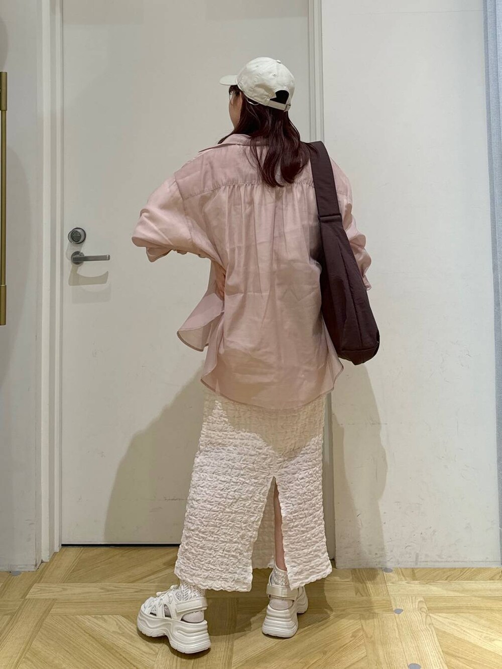 ピンク系のシャツ/ブラウス、ホワイト系のTシャツ/カットソー、ブラウン系のショルダーバッグを着用したレディースの春コーディネートの3枚目の写真