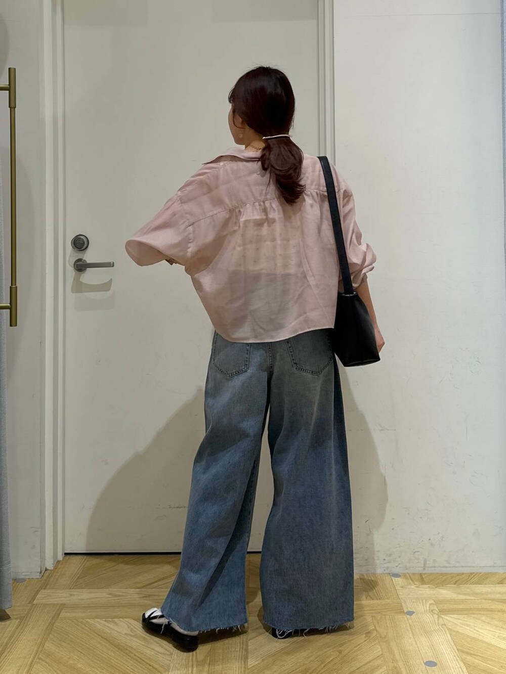 ピンク系のシャツ/ブラウス、ブラック系のサンダル、ブラック系のショルダーバッグを着用したレディースの春コーディネートの5枚目の写真