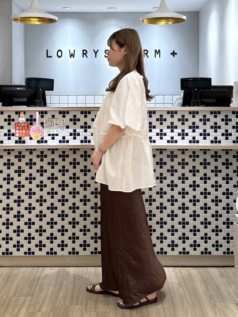 ピンク系のシャツ/ブラウス、ブラウン系のスカート、ブラウン系のサンダルを着用したレディースの夏コーディネートの2枚目の写真