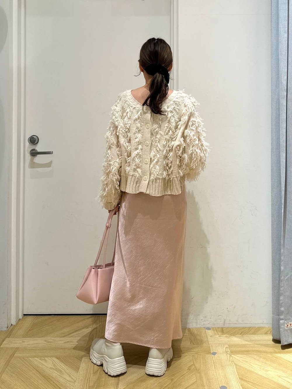 ホワイト系のブルゾン、ピンク系のショルダーバッグ、ホワイト系のブーツを着用したレディースの冬コーディネートの8枚目の写真