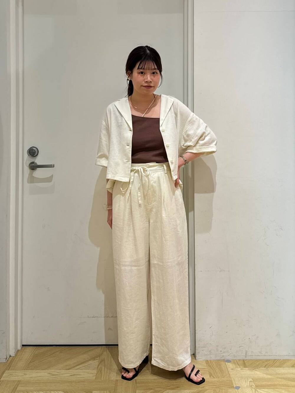 ホワイト系のシャツ/ブラウス、ブラック系のサンダル、ベージュ系のその他パンツを着用したレディースの春コーディネートの2枚目の写真