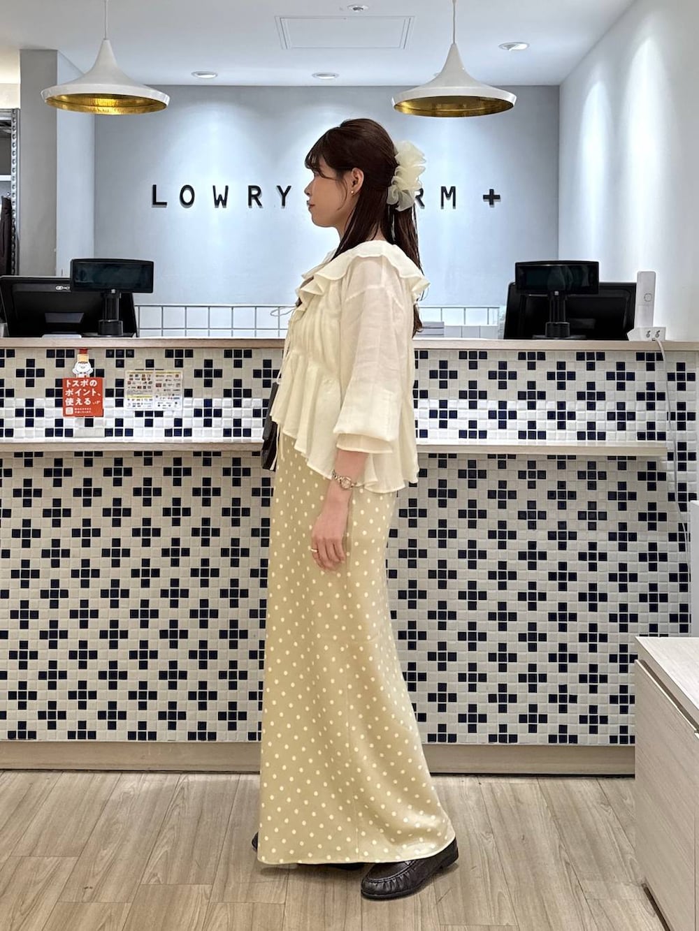 ホワイト系のスカート、ブラウン系のローファー、ホワイト系のタンクトップを着用したレディースの春コーディネートの4枚目の写真