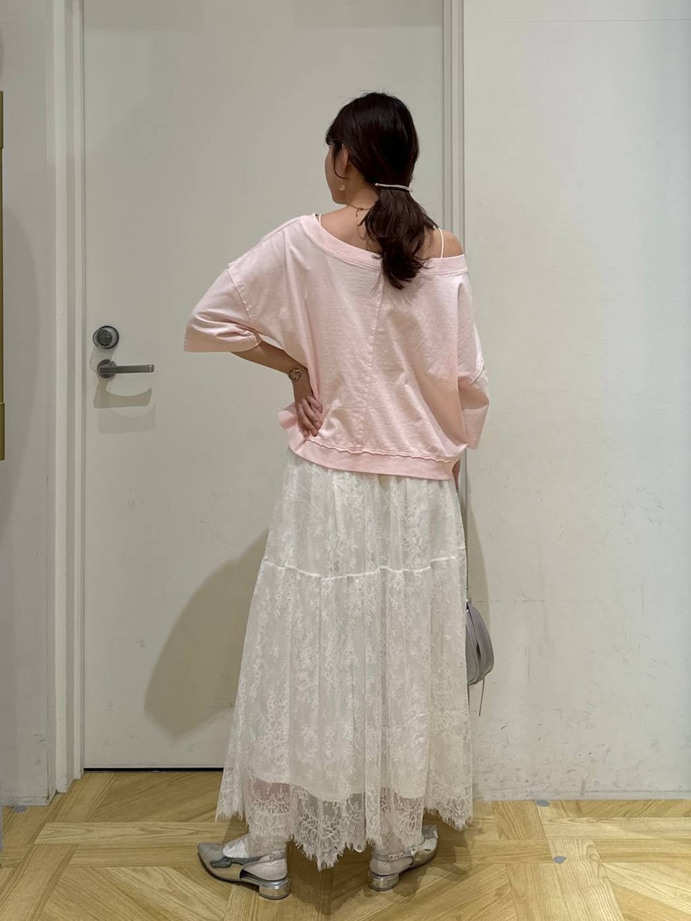 シルバー系のトートバッグ、シルバー系のパンプス、ホワイト系のスカートを着用したレディースの春コーディネートの5枚目の写真