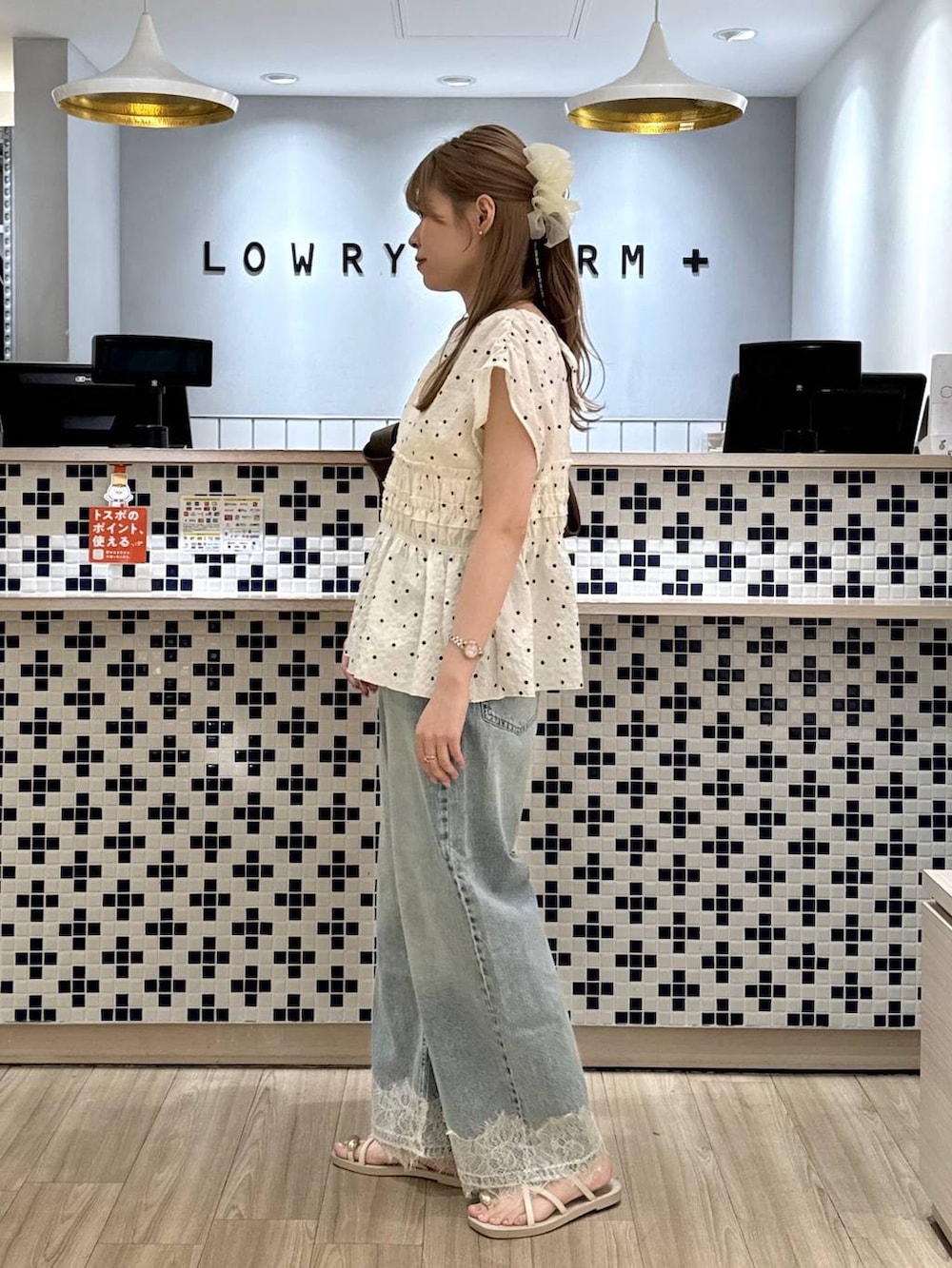ブルー系のデニムパンツ、ホワイト系のサンダル、ブラウン系のショルダーバッグを着用したレディースの夏コーディネートの4枚目の写真