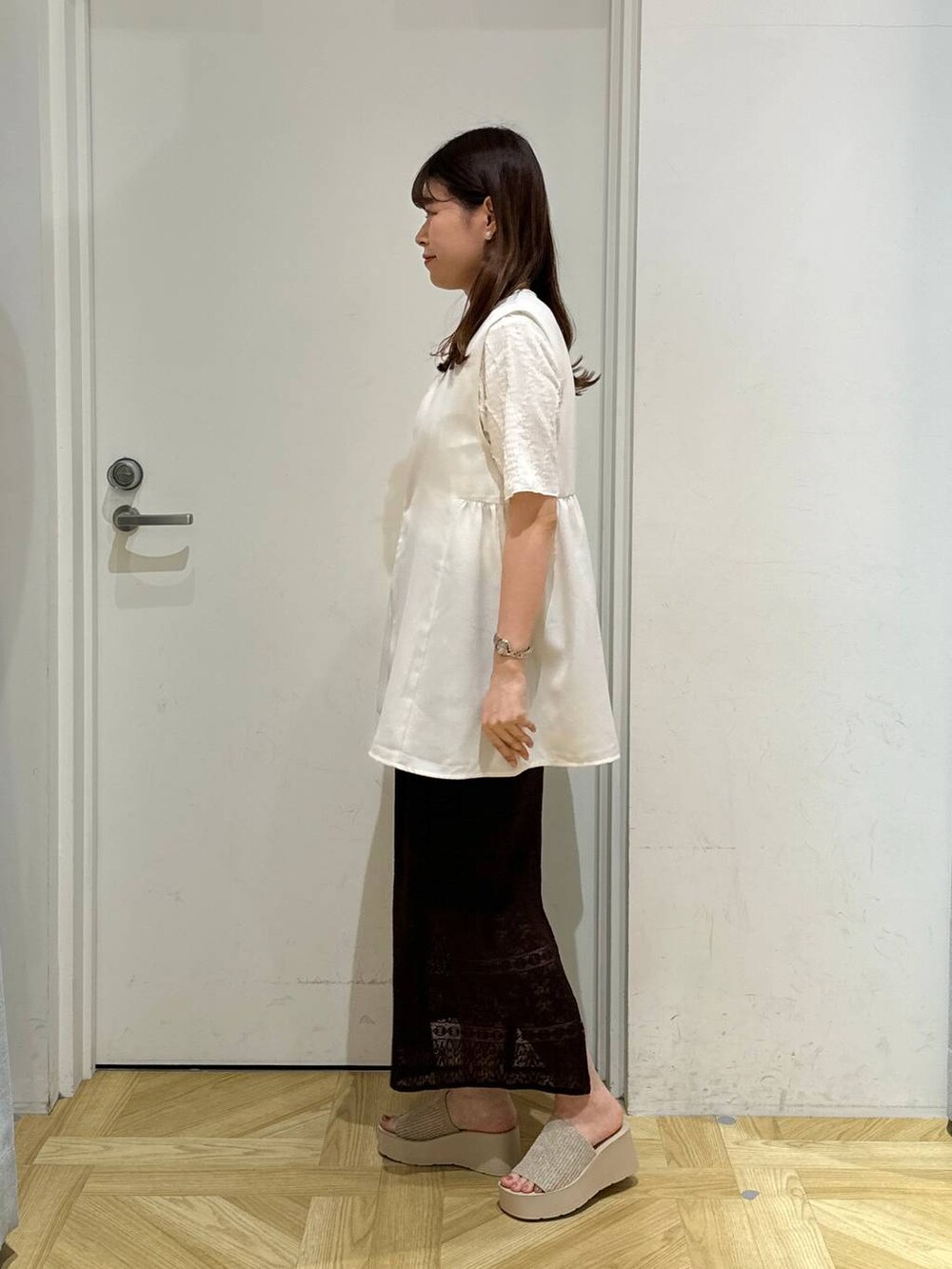 ホワイト系のサンダル、ブラウン系のスカート、ホワイト系のTシャツ/カットソーを着用したレディースの春コーディネートの3枚目の写真