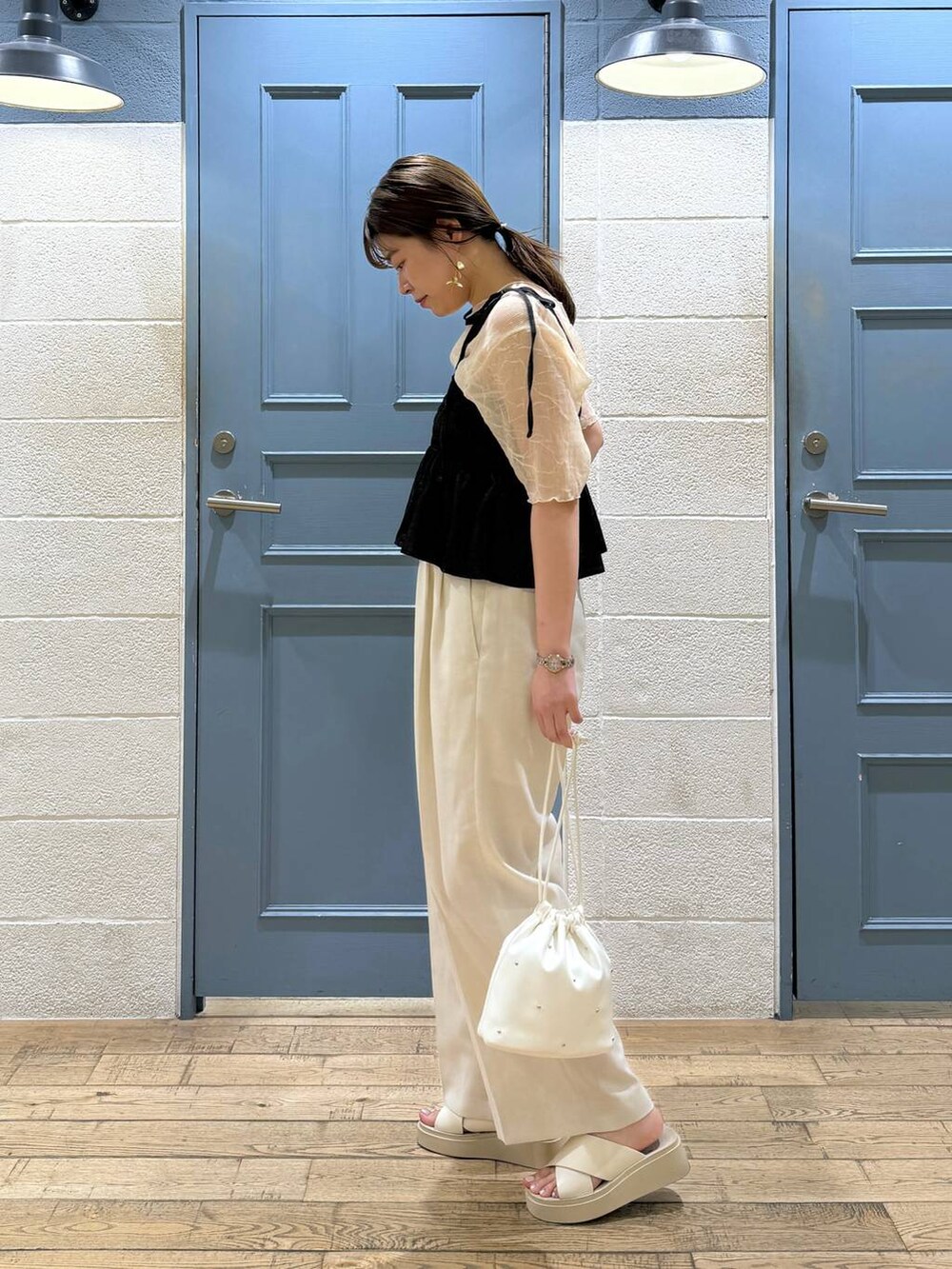 ホワイト系のショルダーバッグ、ホワイト系のTシャツ/カットソー、ホワイト系のサンダルを着用したレディースの秋コーディネートの2枚目の写真