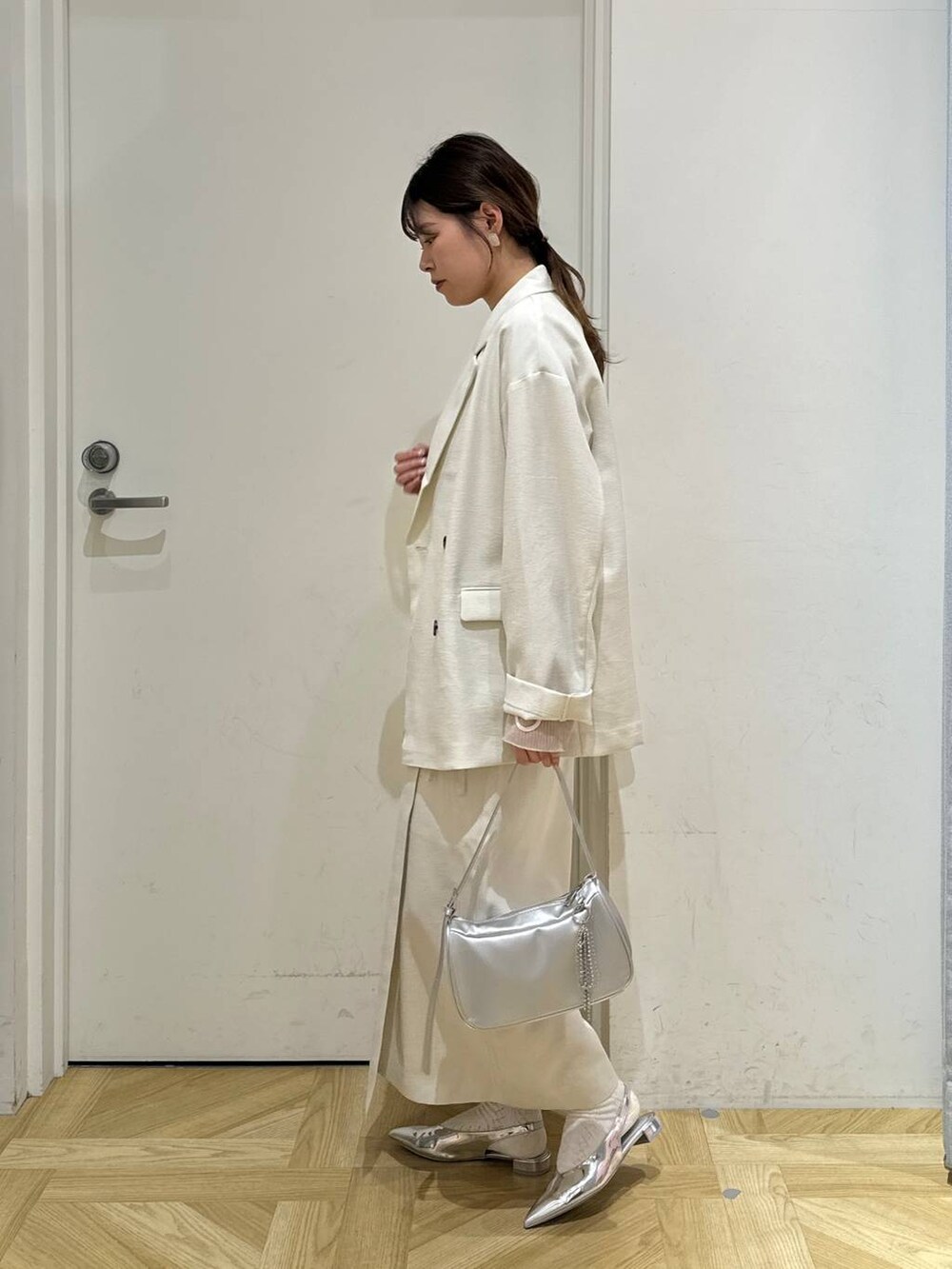 ホワイト系のスカート、ホワイト系のテーラードジャケット、シルバー系のトートバッグを着用したレディースの春コーディネートの3枚目の写真